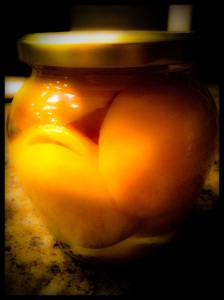 Jar of peaches with vanilla.